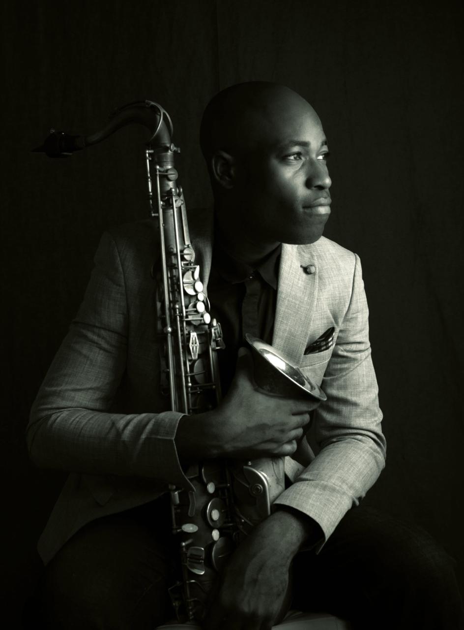 Emmanuel Atoyebi holding his saxophone in a monochrome portrait