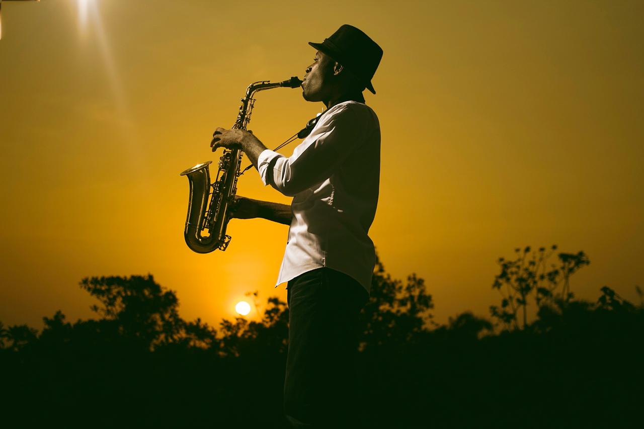 Emmanuel Atoyebi performing saxophone at sunset